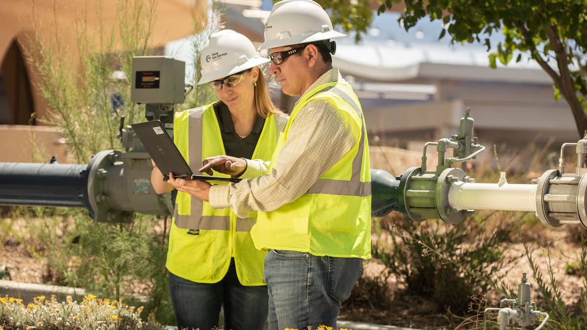 Texas Gas Service employees collaborating with laptop